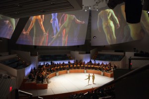 Andrea Weber and Brandon Collwes perform in front of the New World Symphony and beneath archival footage of the Merce Cunningham Dance Company. (Photo by Rui Dios-Aidos)