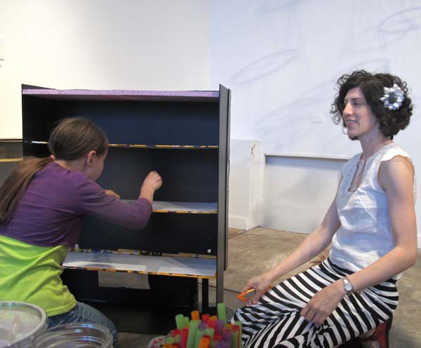 Utchenik and her daughter making some modifications to one of the dollhouses.