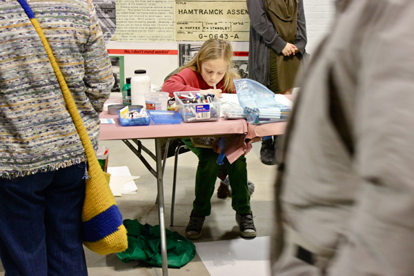 The event's youngest artist, Elvin P., whose portrait of a bird and rabbit was a hot item.