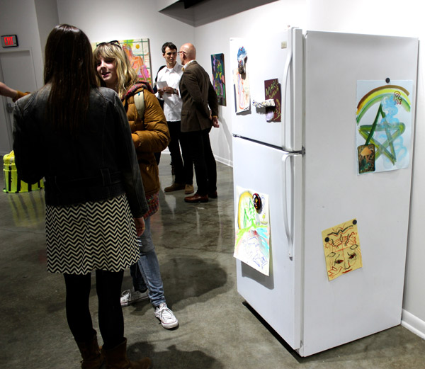 Fridge, with drawing by Katrina Fimmel, magnets by Mike Swaney, and "Freezer" by Rajewski inside, alongside opening night refreshments.