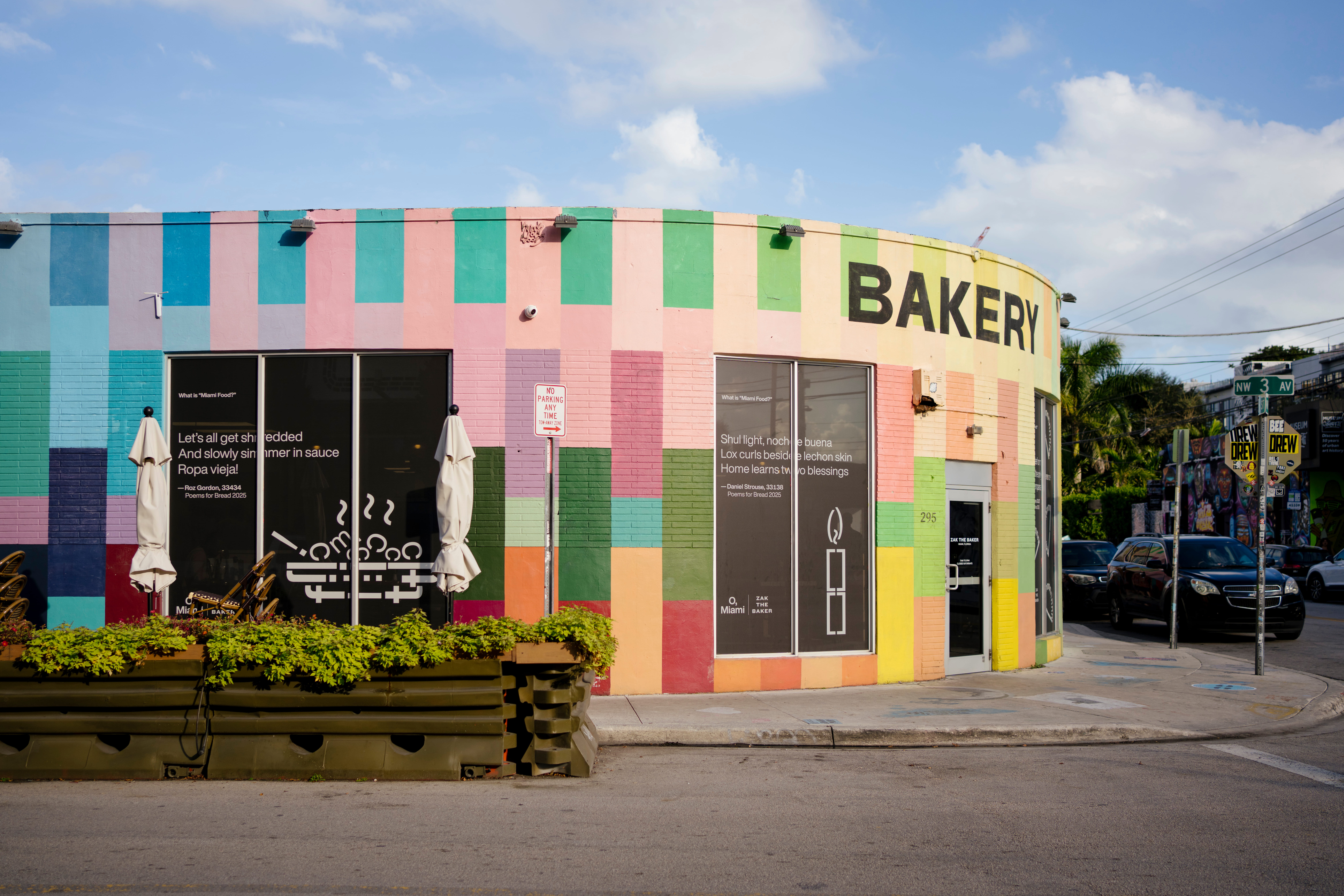 A colorful bakery featuring a geometric mural and poetry on the windows.