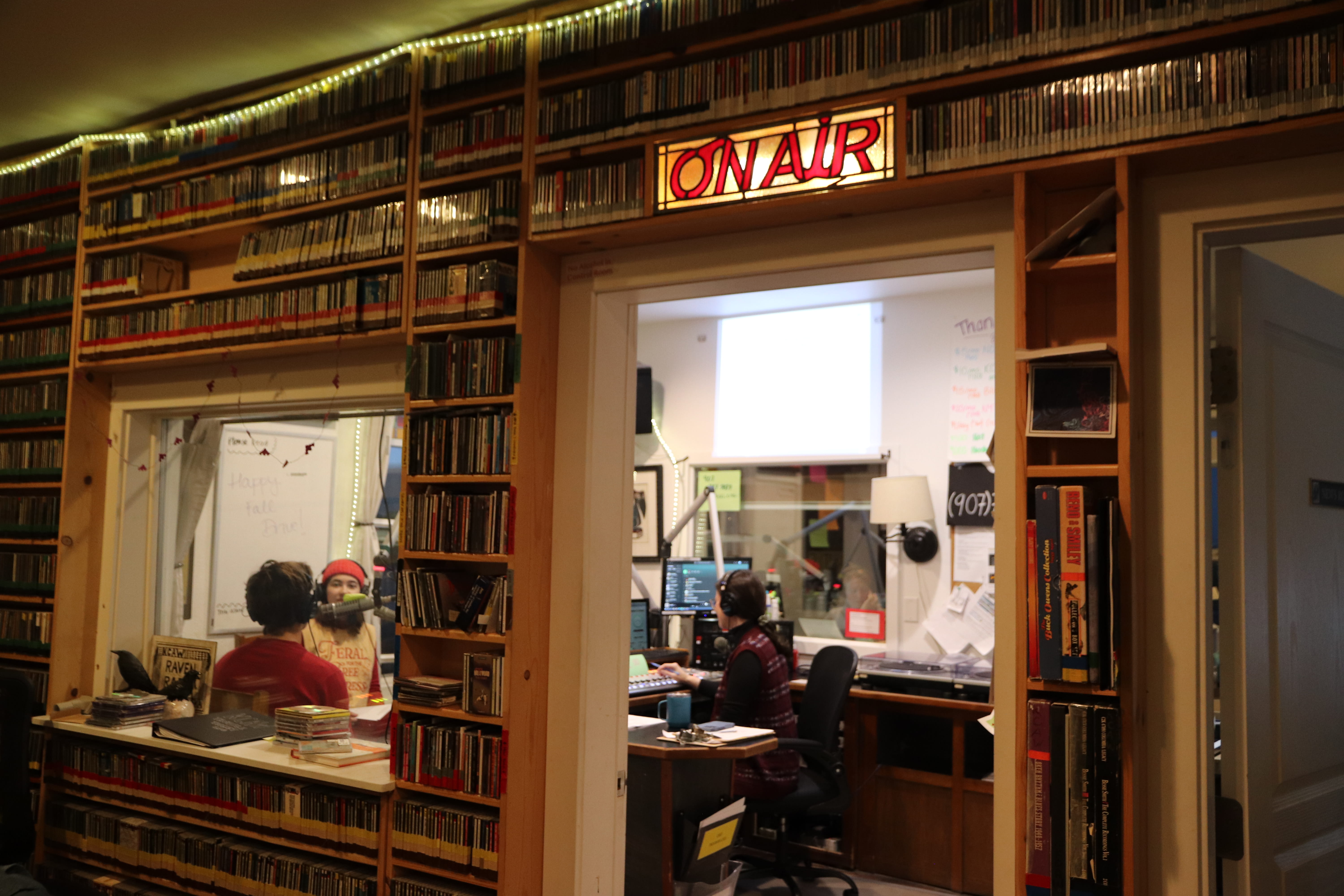 Radio station interior with people working and broadcasting.