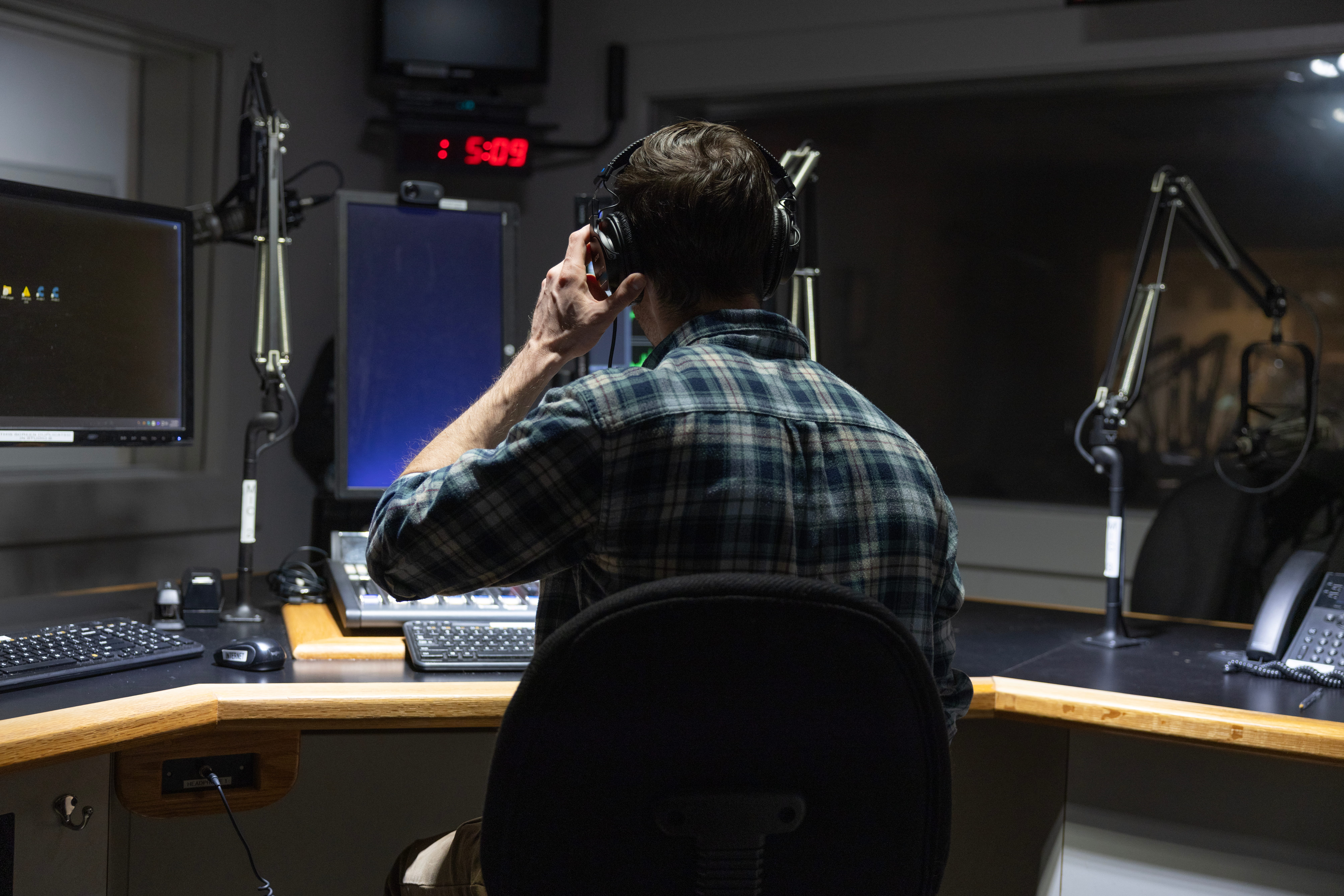 Journalist wearing headphones in a studio.